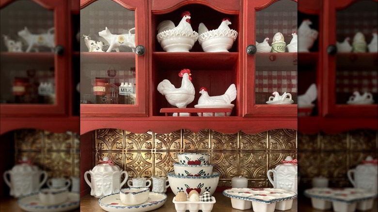 View of red kitchen hutch with gold tin and ceramic serveware