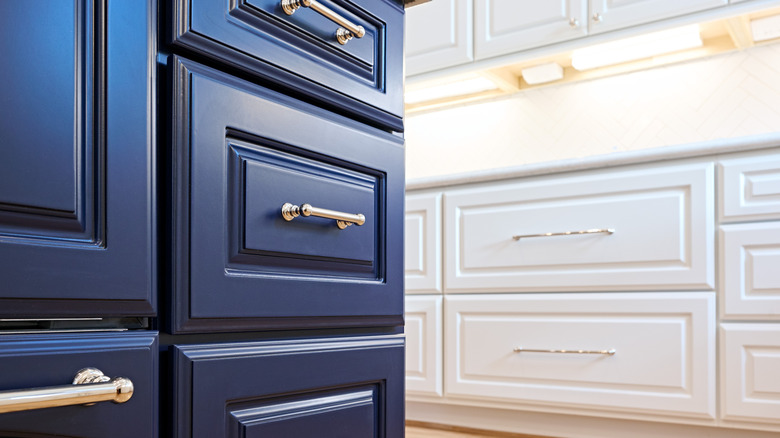 Close-up of navy kitchen drawers with white cabinets in background