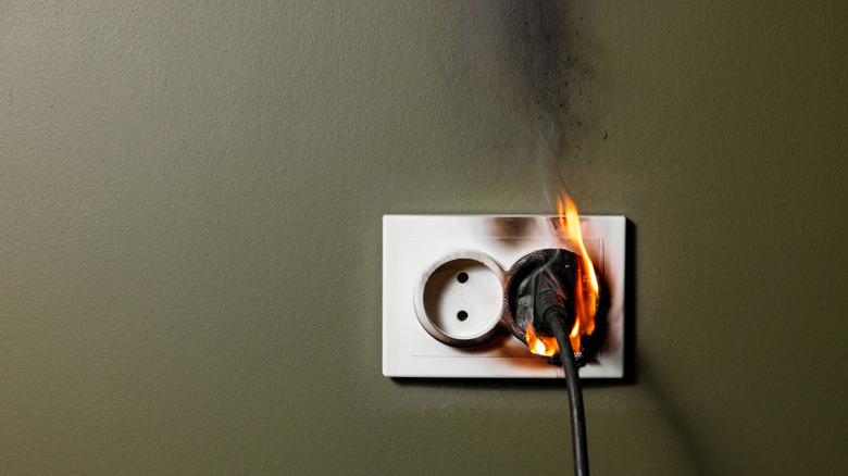 Burning wall socket with plugged in appliance