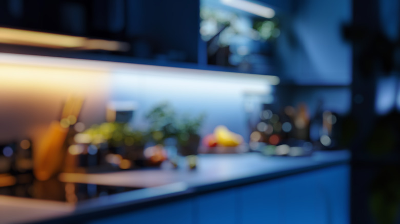 Defocused background of a kitchen with herbs and fruits placed on the counter