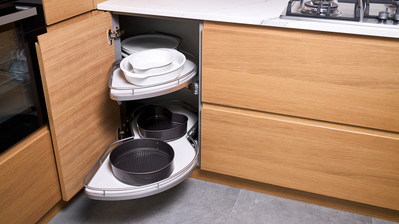 Corner cabinet in kitchen with pans on the shelves