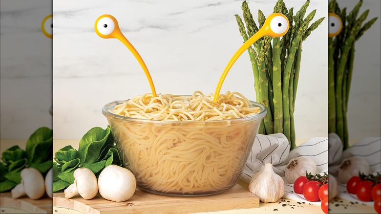 Ototo pasta monsters and salad servers in a bowl of spaghetti