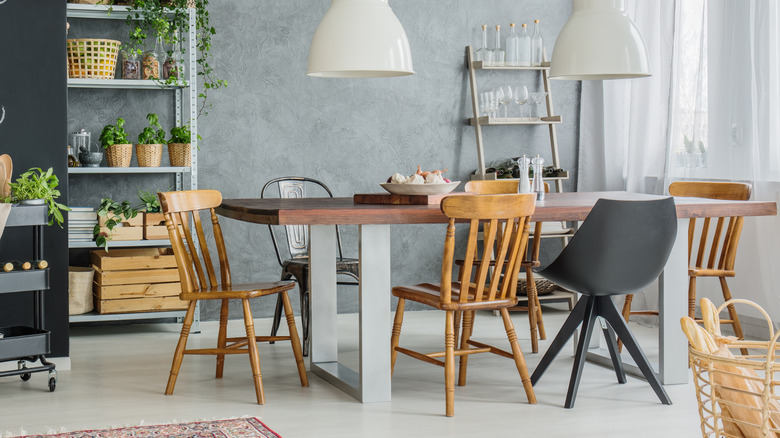 A wooden kitchen table with different chairs