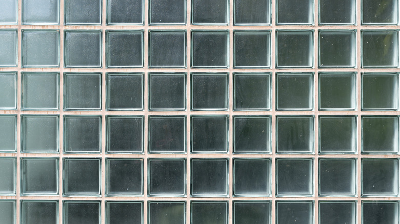 A wall of glass block bricks with peach-colored frame