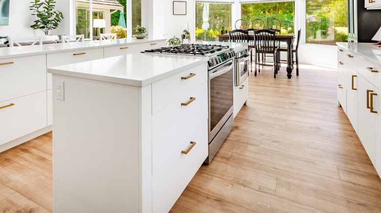 Wooden flooring in a kitchen with a white island