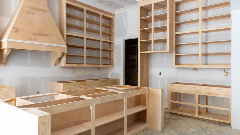 A kitchen being remodeled with wooden cabinets