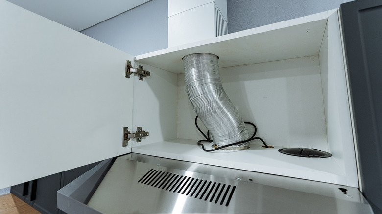 white cabinet and bulkhead concealing the vent running from a kitchen stove's vent hood
