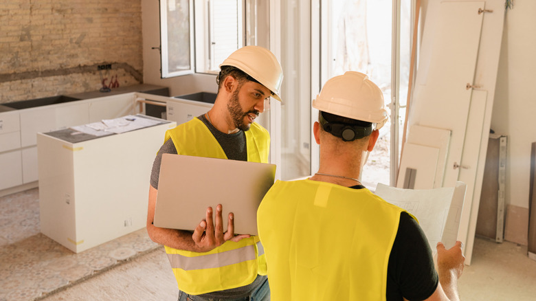two tradesmen in safety vests and hard hats