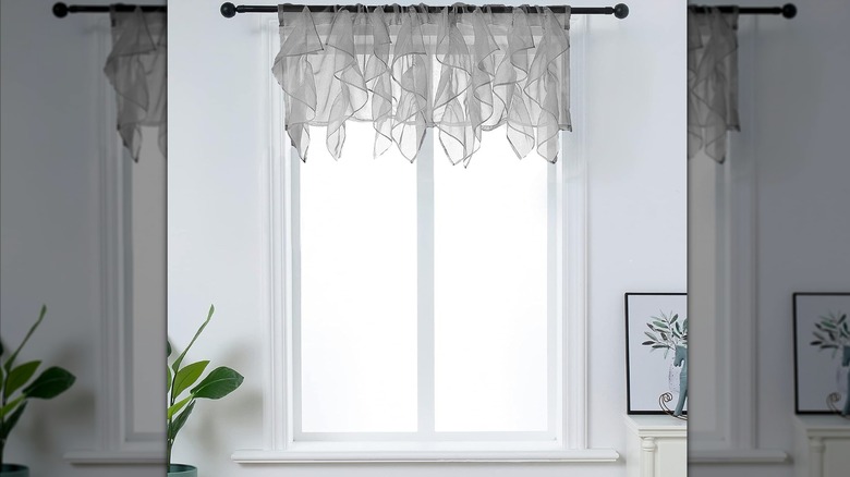 Grey ruffled voile valance on a black window rail