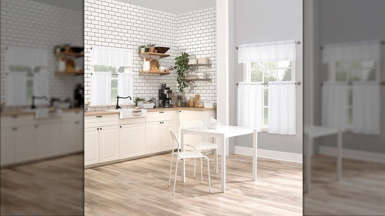A bright kitchen with white valance and tier curtains