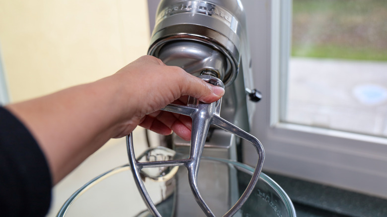 person attaching a kitchenaid accessory