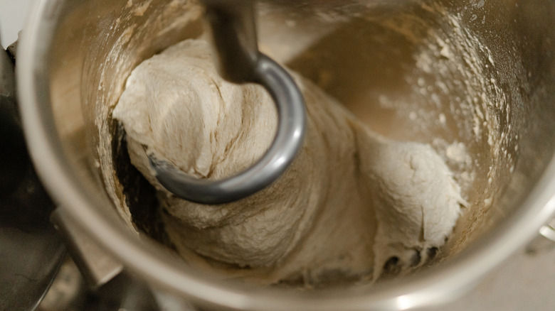 bread dough being kneaded in a stand mixer