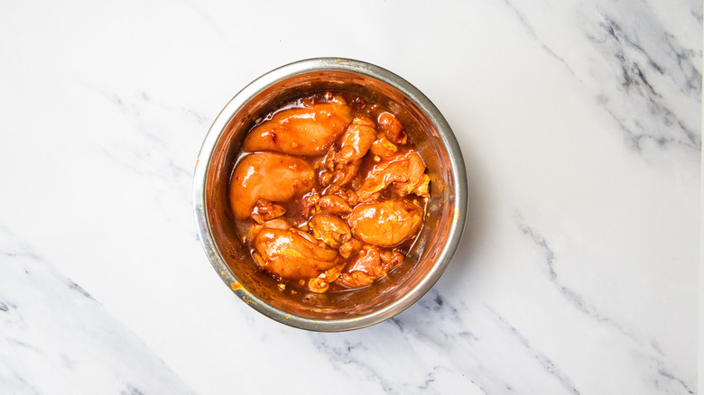 Chicken marinating in bowl.