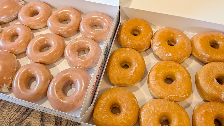 Large open boxes of Krispy Kreme and Dunkin' glazed donuts