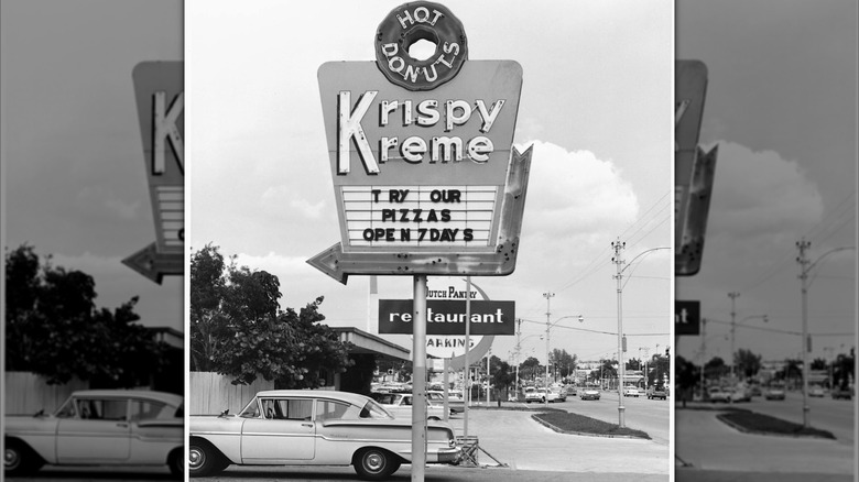 Mirrored image of black and white photo of Krispy Kreme sign advertising pizzas