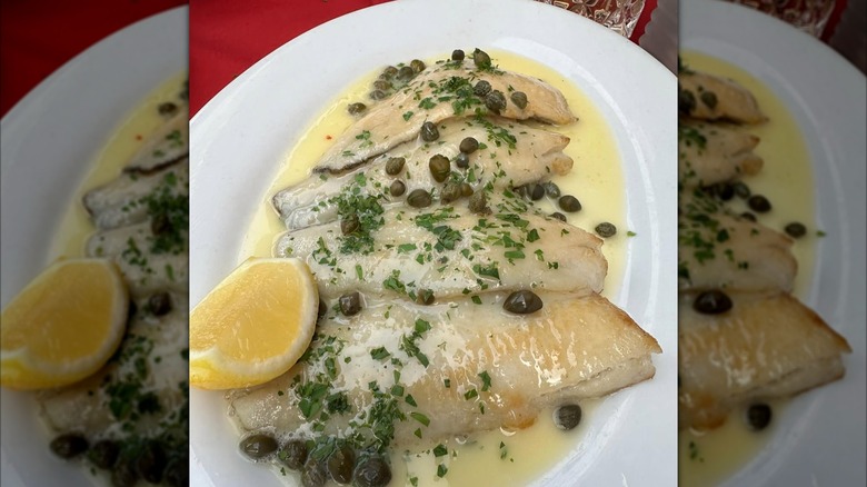 White fish filets topped with a glaze, capers, and parsley