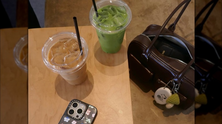 Iced matcha and an iced latte on a wooden table