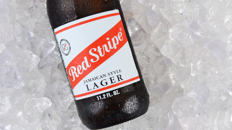 A top down view of a bottle of Red Stripe laid on a bed of ice