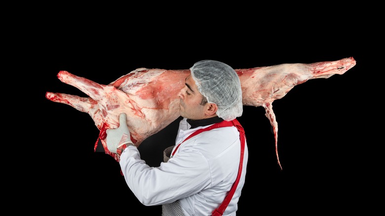 Butcher holding butchered lamb