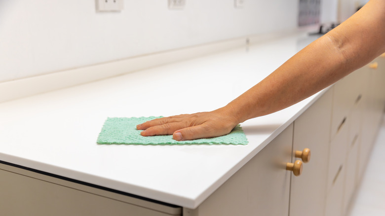 White solid surface countertop being wiped down