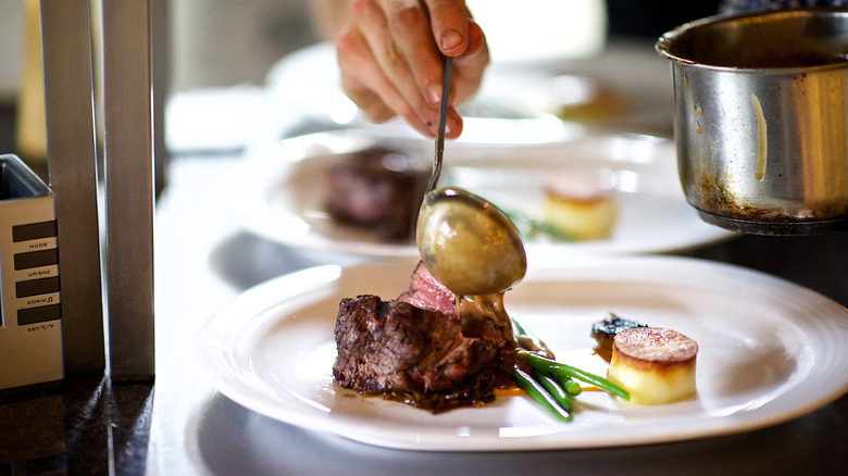 Chef plating a meal at a luxury steakhouse