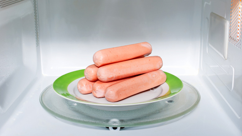 Pile of hot dogs on a plate in the microwave