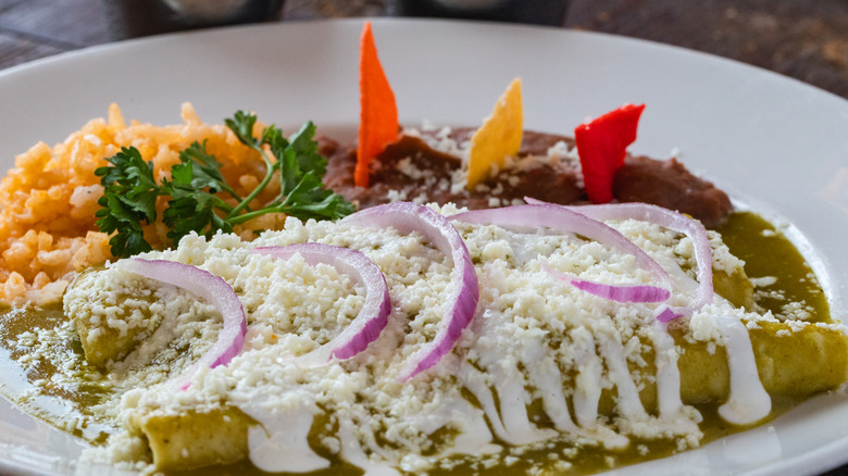 Plate of enchiladas verdes with rice and beans