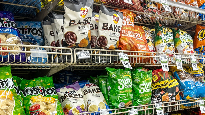 Rows and rows of different chip bags on grocery stores shelves.