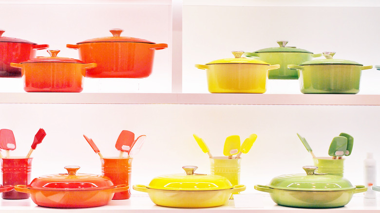 Shelves at a Le Creuset store stocked with colorful Dutch ovens and other cookware