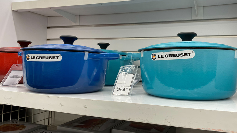 A display of Le Creuset Dutch ovens in shades of blue and red