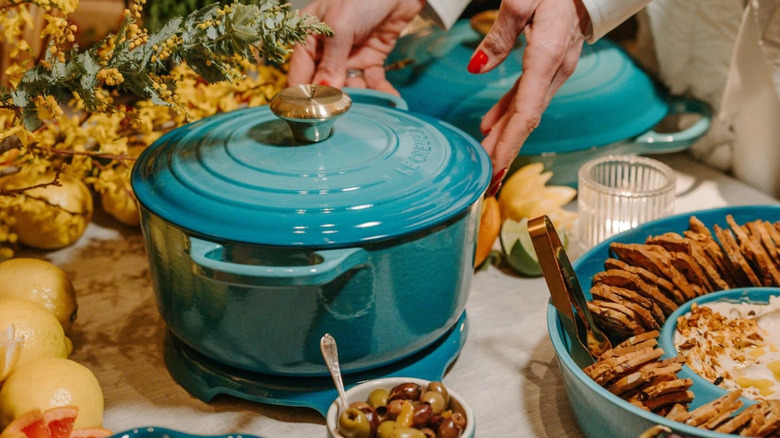 blue Le Creuset pot with other dishes