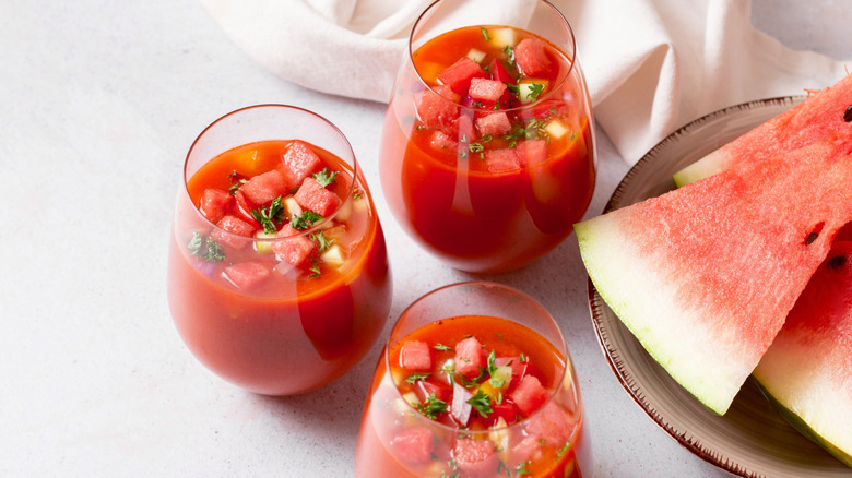 Cups filled with watermelon gazpacho and herby garnish