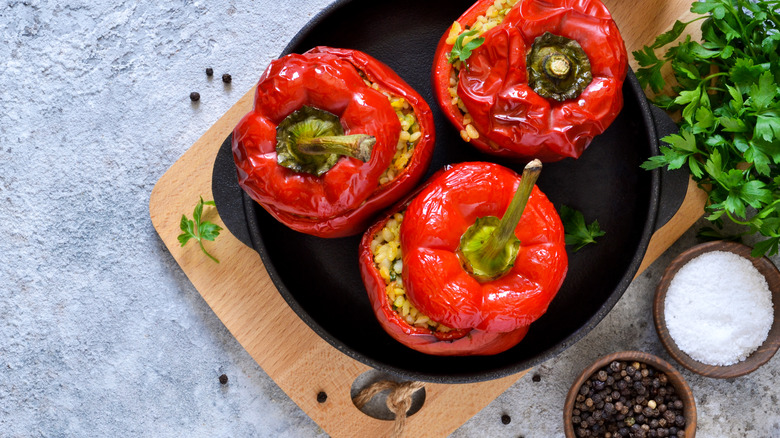 Red bell peppers filled with rice alongside green parsely