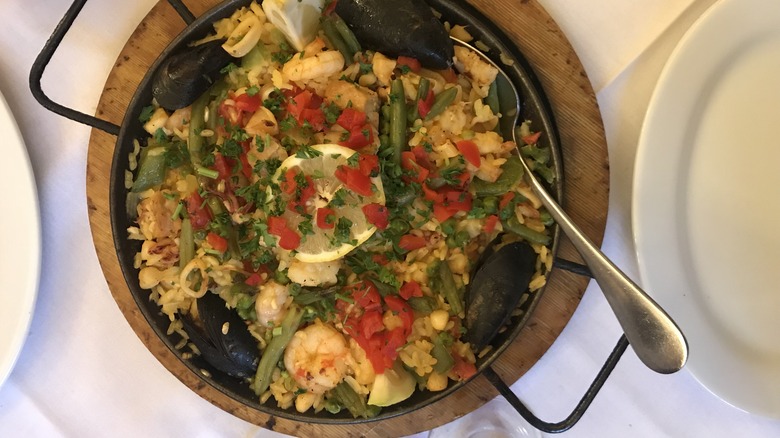 Seafood paella sprinkled with red peppers and green herbs