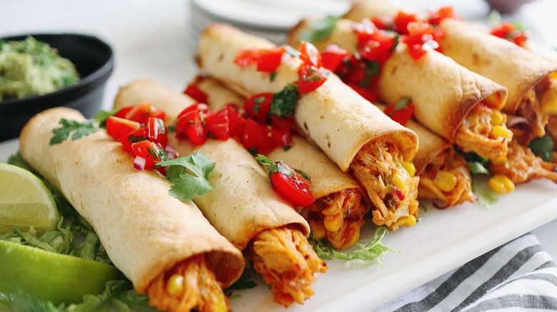 Chicken flautas on serving platter with lime wedges
