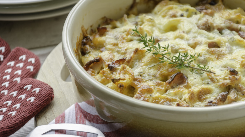 Chicken casserole in white dish with red oven mit