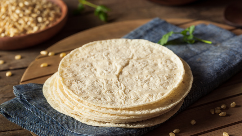a stack of corn tortillas on a kitchen towel
