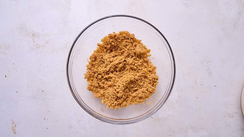 combining graham cracker crumbs in a bowl