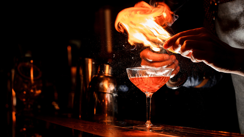 Bartending setting a drink on fire