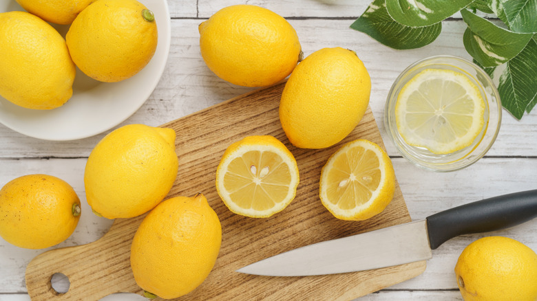Lemons and knife on cutting board
