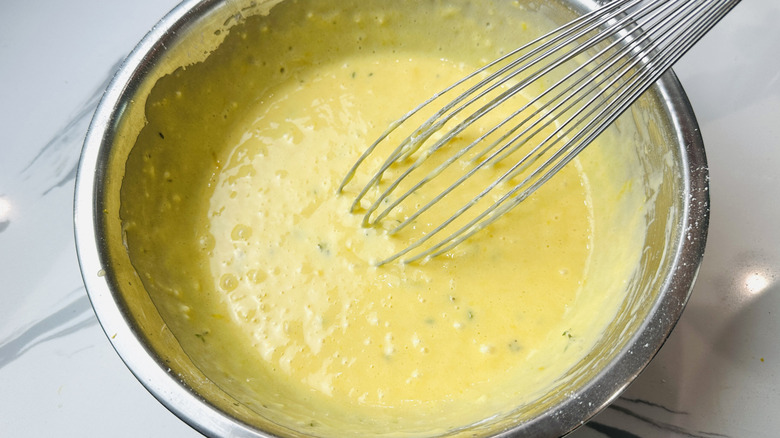 Custardy egg mixture in bowl with whisk