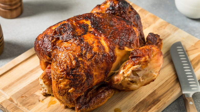 Rotisserie chicken on wooden cutting board