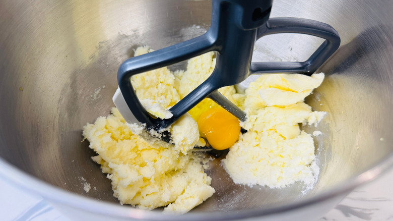Butter and sugar mixture with egg in stand mixer bowl