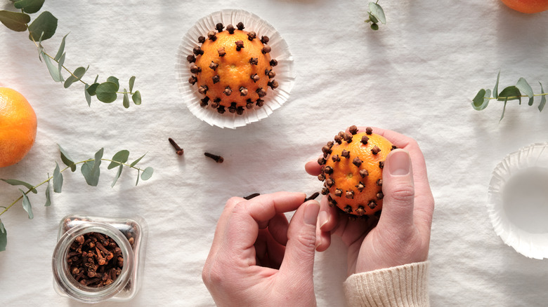 A person making orange pomanders