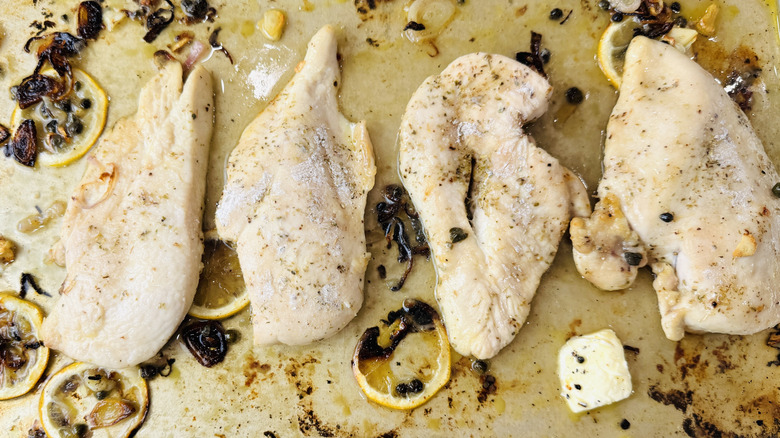 Raw chicken on baking sheet for lemony chicken piccata