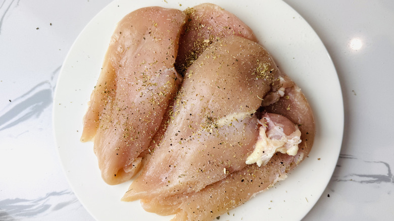 Seasoned raw chicken on a plate