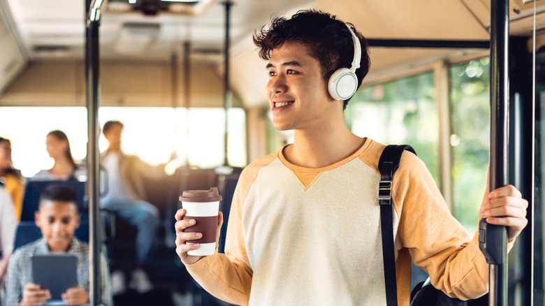 person riding bus with coffee