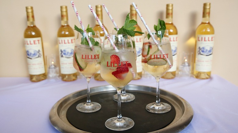 Three Lillet Blanc cocktails on a tray next to bottles