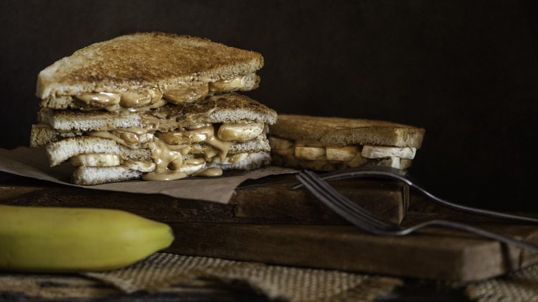 Fried banana and peanut butter sandwich on a wooden board