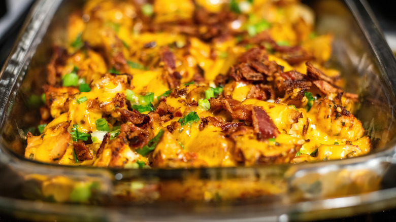 A loaded baked potato casserole in a glass casserole dish